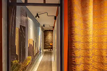 long couloir plongeant avec rideau orange et papier panoramique