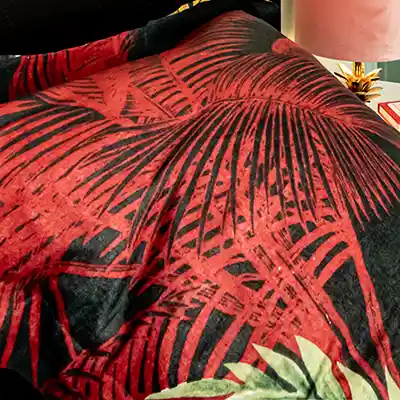 L'oreiller avec des feuilles de jungle rouges